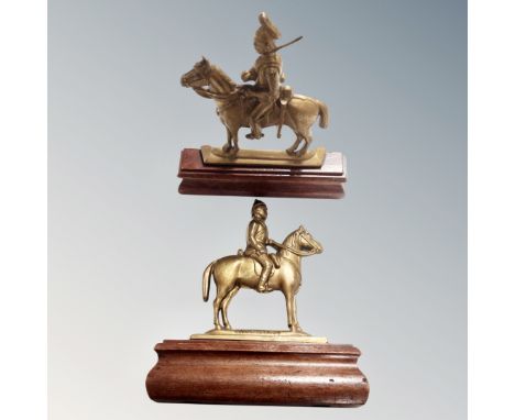 A pair of antique brass military figures on horseback, mounted on wooden stands. 