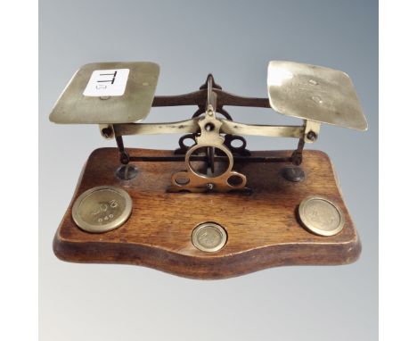 A set of antique post office scales with weights mounted on board 