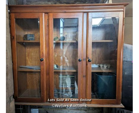 Glazed pine wall cupboard, 3 opening doors, glass intact, 2 shelves. Wired for lighting, not PAT tested.  Note cut out in bac