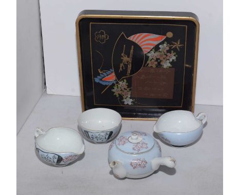 A War-Era Japanese ceremonial tea service, comprising tea pot, two cream jug and tea bowl, decorated with cherry blossoms and