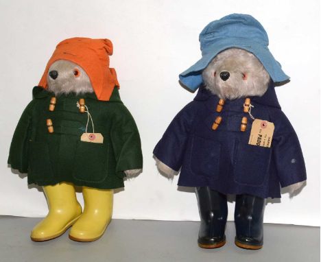 Two Gabrielle design Paddington Bear cuddly toys, one with blue hat, dark blue duffle coat (with label), and blue Dunlop well