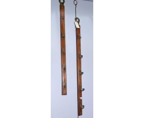 A pair of brass-mounted mahogany wall hanging coat rails, each mounted with five brass hooks and 89cms high.