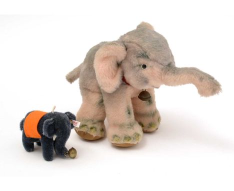 Two Steiff elephants, one with plastic eyes, a bell around the neck and button ear, 19cms high; the other with felt saddle an