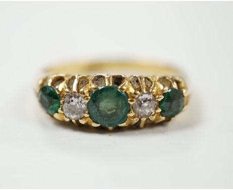 An early 20th century 18ct, three stone green garnet and two stone diamond claw set half hoop ring, size L, gross weight 4.8 