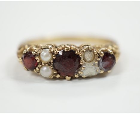 A modern 9ct gold, three stone garnet and four stone split pearl set half hoop ring (two pearls missing), size S/T, gross wei