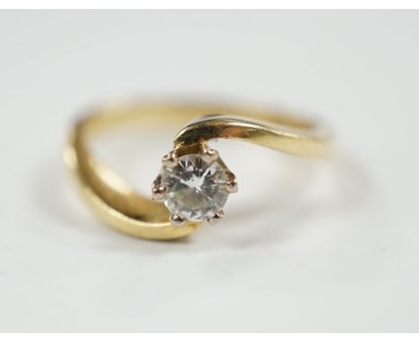 A modern 18ct gold and solitaire diamond set ring, with crossover shoulders, size K, gross weight 4 grams.