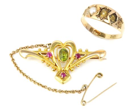 Peridot and ruby brooch, an oval cut peridot centrally set within an openwork heart shaped brooch, with three round cut rubie