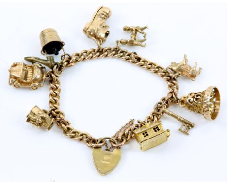 A gold charm bracelet, curb link chain with a heart padlock clasp, hallmarked 9 ct, London 1983, with ten charms including a 