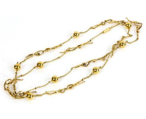Long gold necklace, the necklace depicting two figures linked together, each pair separated by a chain and ball, in tested 18