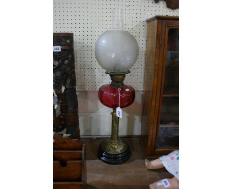 An Antique Brass Column Oil Lamp With Cranberry Tinted Reservoir