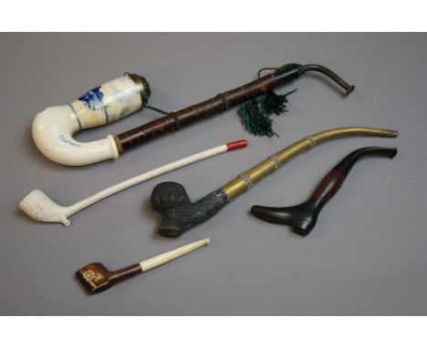 A Dutch ceramic pipe with a horn mouthpiece; A clay Churchwarden pipe; a Cutty pipe and two others