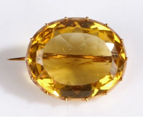 A 9 carat gold and yellow stone set brooch, of oval form and facetted edge,&nbsp;23 x 19mm, 6.20 grams.