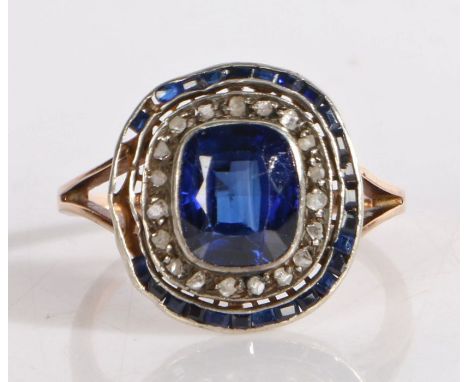 Sapphire and diamond ring, the central step cut sapphire surrounded by a band of diamonds and small baguette cut sapphires, r