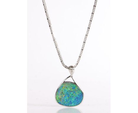 A modern 18 carat gold and black opal pendant necklace, the pendant is comprised of an opal slice set in gold with diamond se