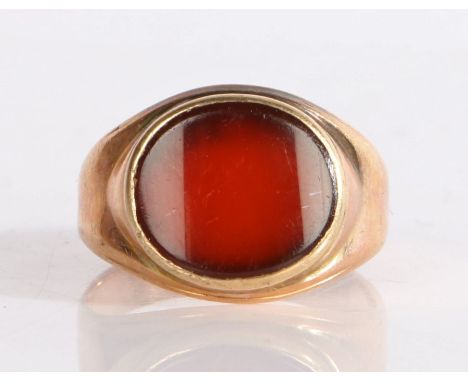 A 19th Century oval cut carnelian ring, set across the width of the ring in a raised mount, 4.09 grams, ring size K.
