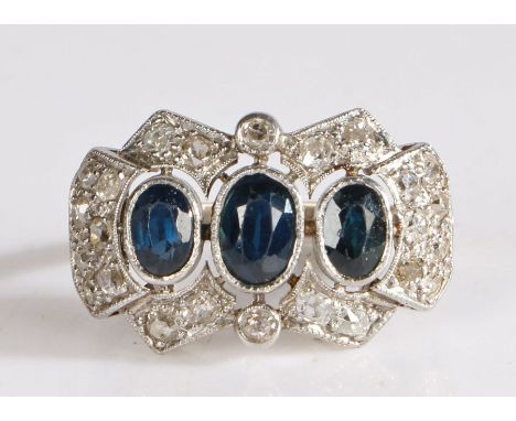 White metal diamond and topaz plaque ring, having three graduated oval cut topaz stones framed by an elegant geometric diamon