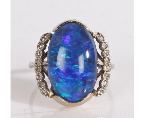 Black opal and diamond ring, the central oval opal flanked by pierced arched shoulders each set with eight diamond chip, ring