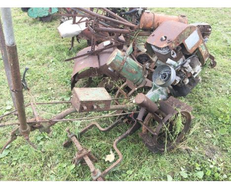 A vintage Tractor with wide open steel wheels and with back bar for hoe and other attachments.