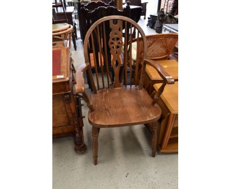 An oak carver dining chair with stick back and medium stain