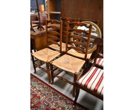 A set of four traditional oak rush seated ladder back chairs