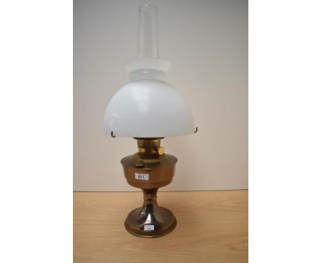 A vintage oil lamp complete with glass shade and chimney.