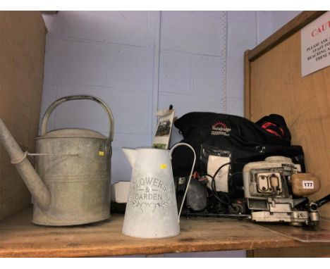 A shelf of assorted, to include watering cans and hedge trimmer etc.