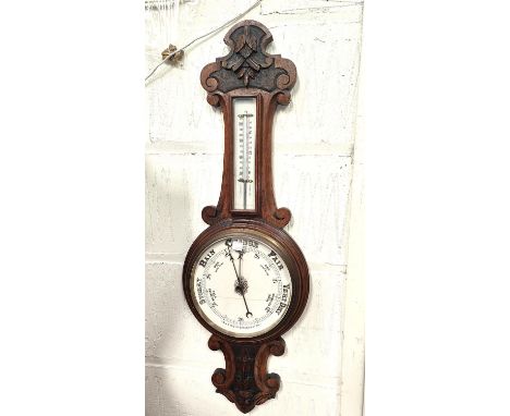 An Edwardian carved oak barometer with thermometer 