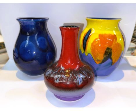 Three 1970's Poole vases:&nbsp; orange/yellow baluster form vase, height 17cm; a red slender neck vase, height 17cm; a blue b