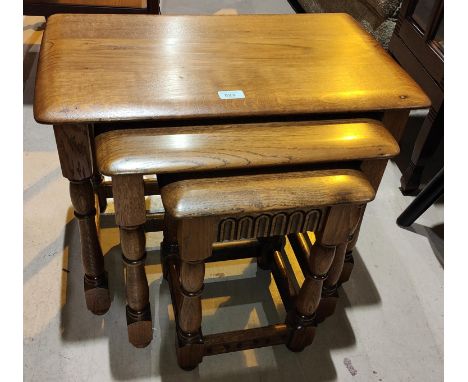 An Ercol style nest of 3 light oak occasional tables; a oak occasional table with square top; a firescreen 