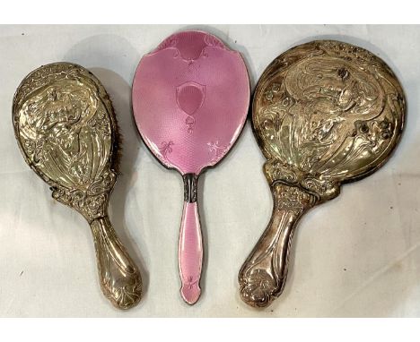 An Art Nouveau embossed mirror and brush (a.f) and a  hall mark silver and pink enamel hand mirror.Pink miror: Although the c