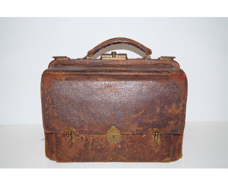 A Victorian leather Gladstone bag with two red leather lined interior compartments containing a removable section fitted with