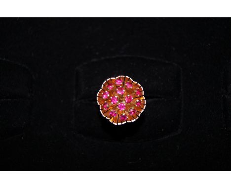 Yellow metal tested for high carat ring set with a cluster of floral stem possibly ruby. Size R