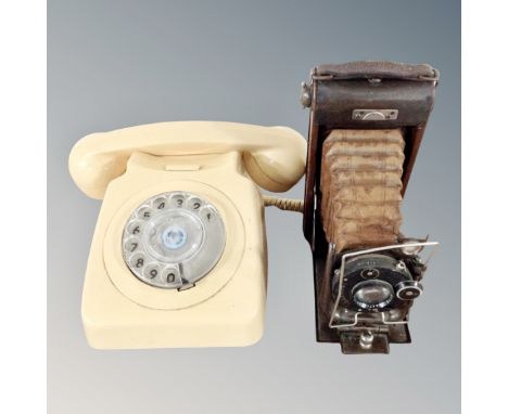 A cream bakelite cased rotary dial telephone together with a carbine vintage camera 