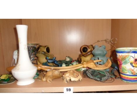 Shelf of assorted frog ornaments