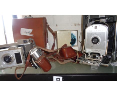 Polaroid Land Camera, model 130 with case, a Polaroid J33 land camera, a Polaroid Flash gun and Paxette 1A camera with a Prix
