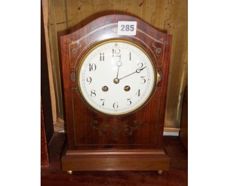 Edwardian inlaid mahogany arch topped mantle clock with French movement, striking on a gong and having 5" white enamel dial
