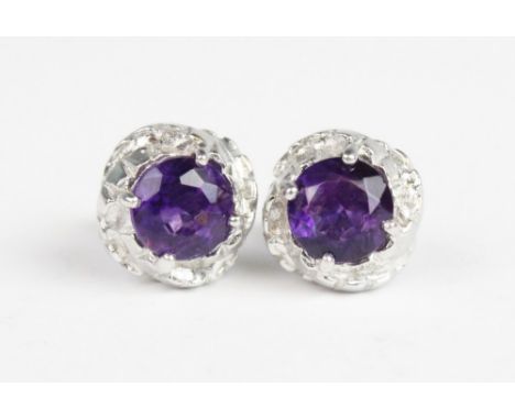 A pair of amethyst set 9ct gold stud earrings, each comprising a round mixed cut amethyst measuring 7mm diameter, claw set in