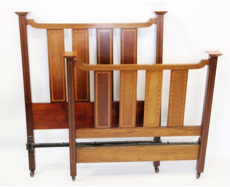 A pair of Edwardian mahogany slatted single beds, with satinwood crossbanded vertical rails, raised upon legs of square secti