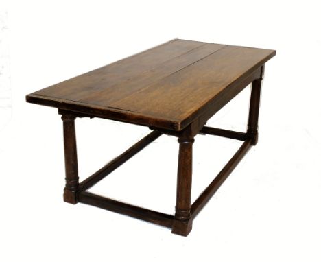 A 17th century style oak refectory table, early 20th century, the cleated three plank top raised upon ring turned tapering cy