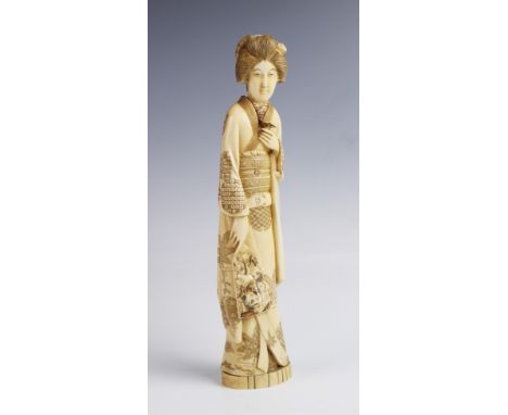 A large Japanese signed ivory okimono, Meiji period (1868-1912), designed as a geisha modelled in a kimono holding a mirror, 