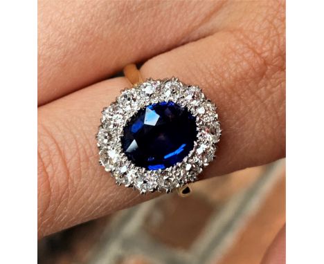 A sapphire and diamond cluster ring, the central oval, mixed cut sapphire (measuring approx 3.16ct), within a surround of fou