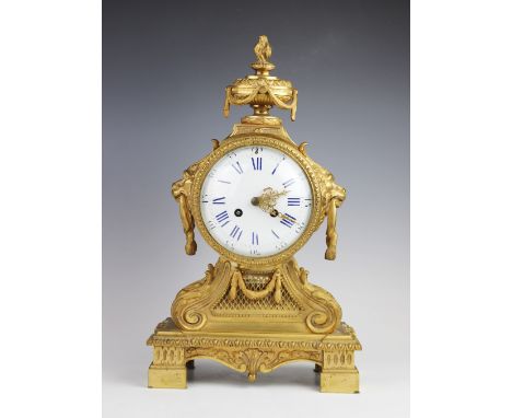 A late 19th century French gilt metal mantel clock, the case surmounted with an urn shaped finial, above the 13cm enamelled d