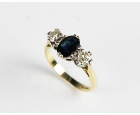 A diamond and sapphire three-stone ring, the central oval mixed cut sapphire measuring 7mm x 5mm, with a round brilliant cut 