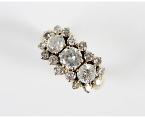 A diamond cluster ring, comprising a central round brilliant cut diamond weighing approx. 0.75 carats, with a further diamond