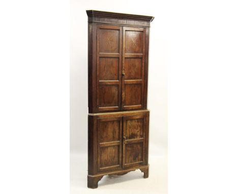 A George III oak freestanding corner cupboard, the moulded cornice above a frieze inlaid with vertical chevron banding, over 