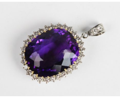 An amethyst and diamond pendant, the central cushion cut amethyst measuring approx. 28mm x 23mm x 17mm, claw set in yellow me