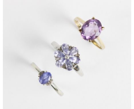 An iolite and diamond floral dress ring, comprising six untested teardrop shaped iolites interspersed by small baguette cut a