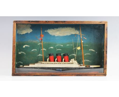 A vintage cased handmade, scratch-built model of a three funnelled ocean going liner, the wooden model set to a naively paint