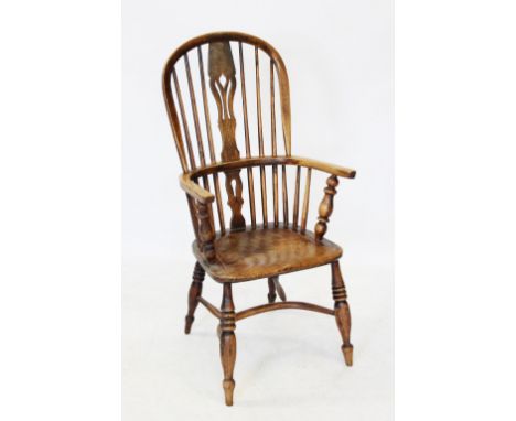 A 19th century elm and ash hoop back Windsor farmhouse elbow chair, with a central pierced splat above plain out swept arms r