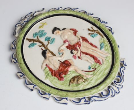 A late 18th century pearlware plaque, circa 1790, of oval form decorated in relief depicting the judgment of Paris, scroll su
